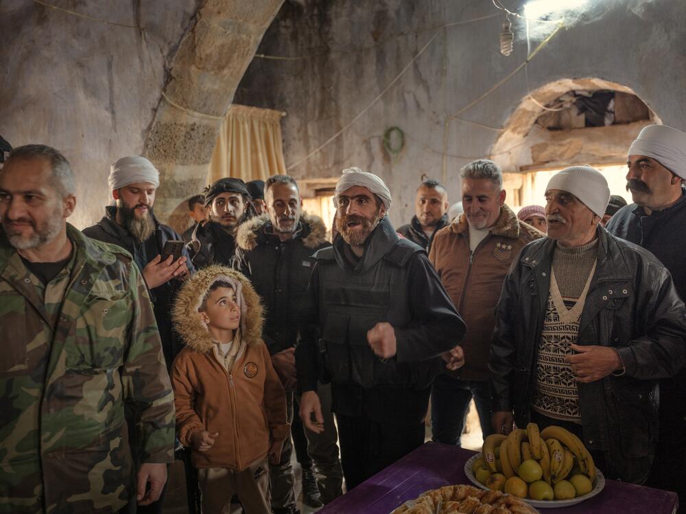 Men gathered to pledge their allegiance to the new militia, whooping and singing while performing a battle version of a celebratory dance, March 8.