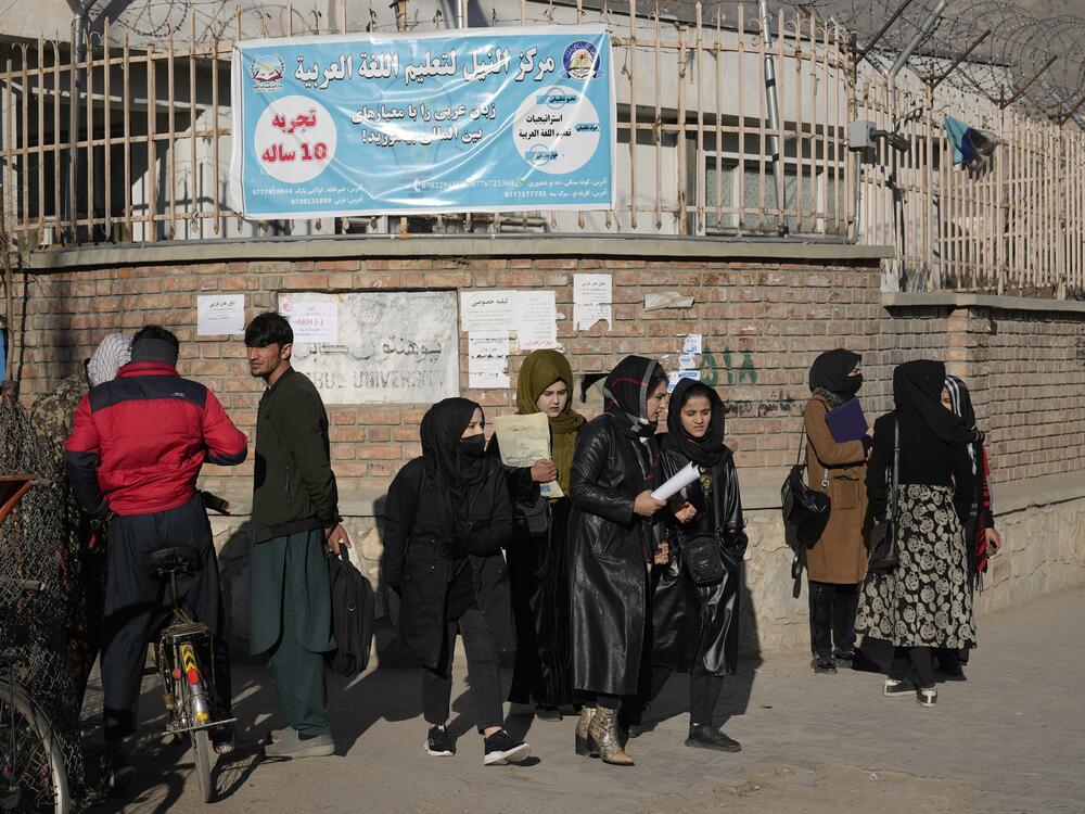 Women students stand outside Kabul University in Afghanistan. As of December 2022, the Taliban has banned women from higher education. But for some, a USAID grant provided online options as well as a chance to study abroad. That scholarship program has now been terminated.