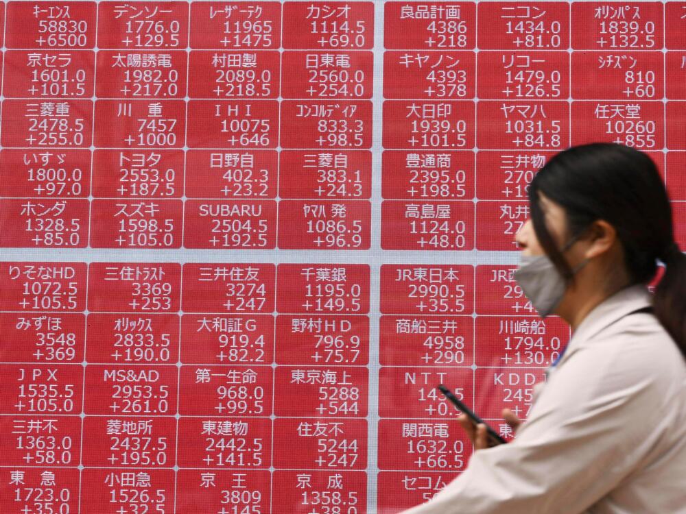 A person walks past an electronic stock board at a securities firm in Tokyo on Thursday.