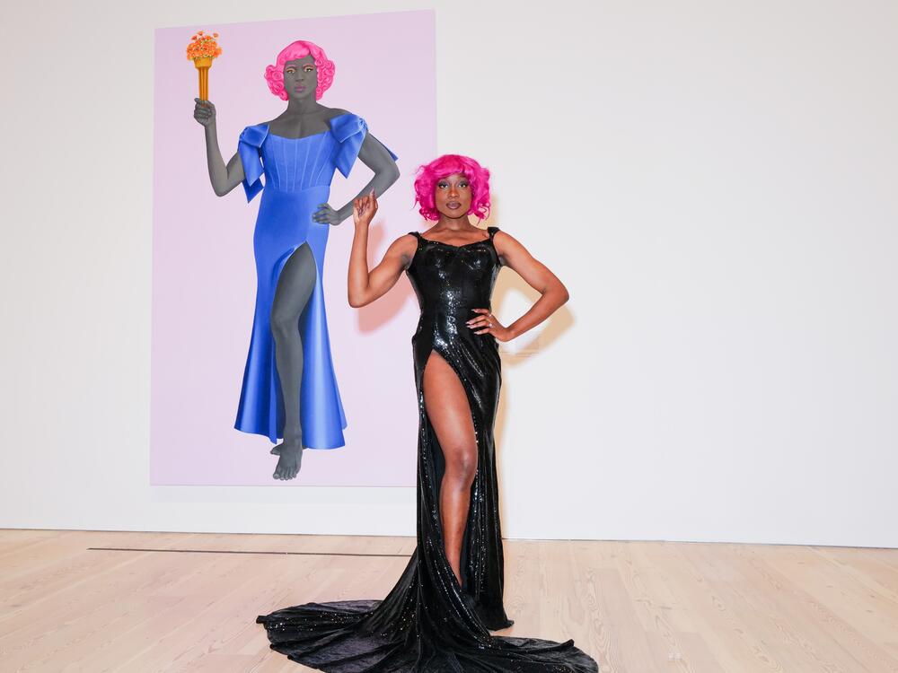 Arewà Basit poses in front of <em>Trans Forming Liberty </em>(2024), a 10-foot oil painting by Amy Sherald for which she served as the model.