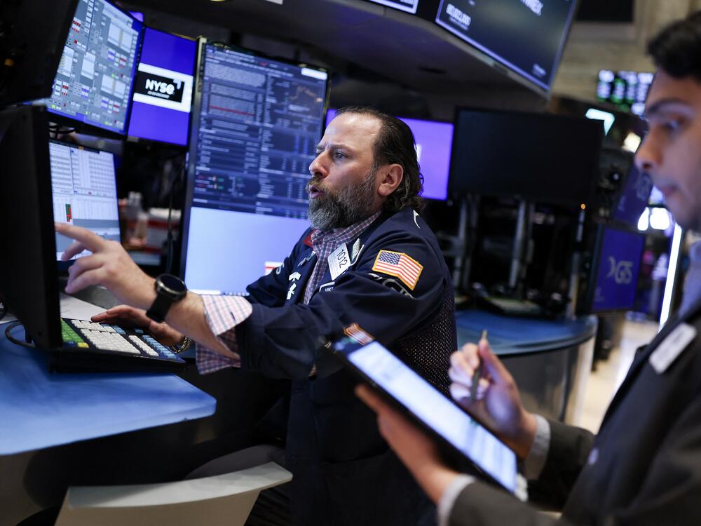 Traders work on the floor of the New York Stock Exchange at the opening bell on Thursday in New York City. Stocks resumed declines after gaining spectacularly a day earlier.