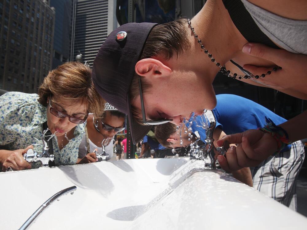 People drink water from a water fountain in New York City on July 7, 2010.