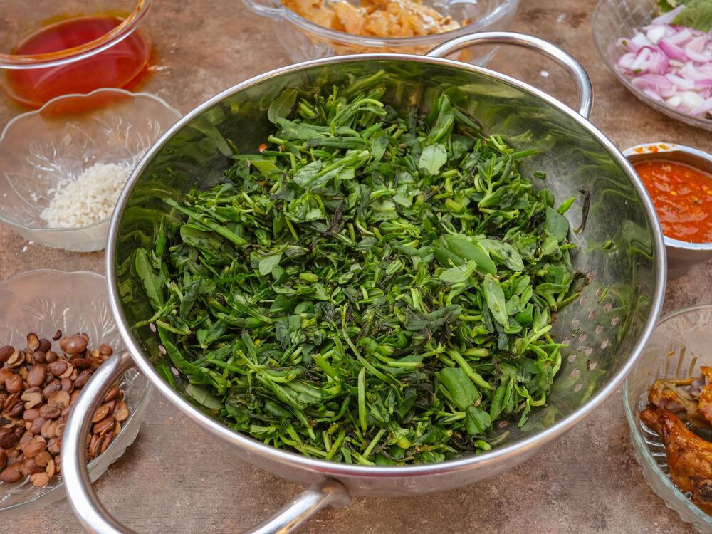 A spread of fresh ingredients used in waterleaf soup include waterleaf (<em>gbure</em>), crayfish, chicken, cowskin, stockfish, turkey, palm oil, locust beans, onions and salt.<br>
