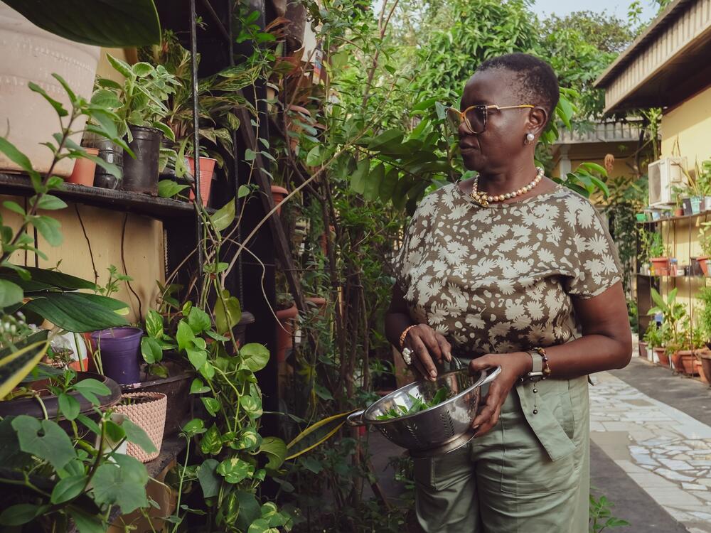 Belinda Odeneye, 60, is an environmental scientist, a retired civil servant and a mother who makes soup. Above, she harvests fresh waterleaf — <em>gbure</em> — from her home garden.  It's a key ingredient in the dish.<br>