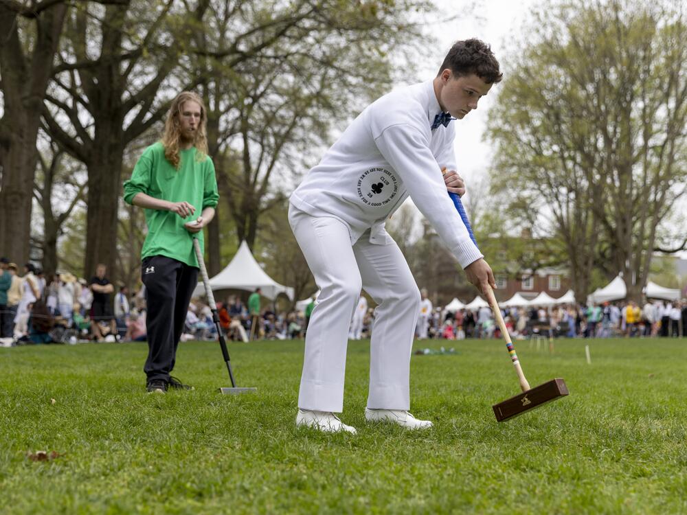 Naval Academy's Walker French swings the mallet as St. John's Caden Marshall watches.