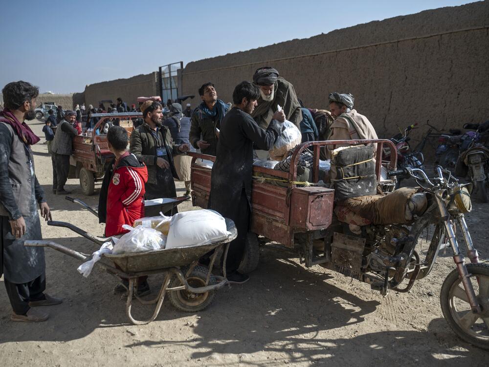 Afghan men load up food packets that were distributed as aid by the World Food Programme. Last weekend, all USAID contracts supporting humanitarian aid from WFP and other agencies in Afghanistan were canceled.