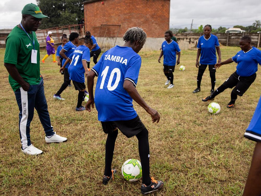 After their bus broke down en route to the tournament, team Zambia hitchhiked to the stadium. Above: The team warms up after their delayed arrival.<br>