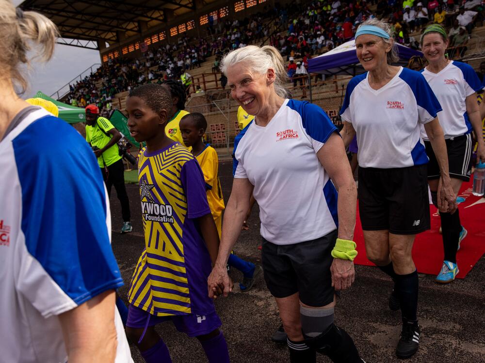 Pam Woodworth, Margot Rendall and Anne Snelling-Lee from the New England Breakers walk onto the field for their game against Togo's team Femme Foot. Youth from local soccer clubs held hands with players from each team as they made their way on to the field before each game.
