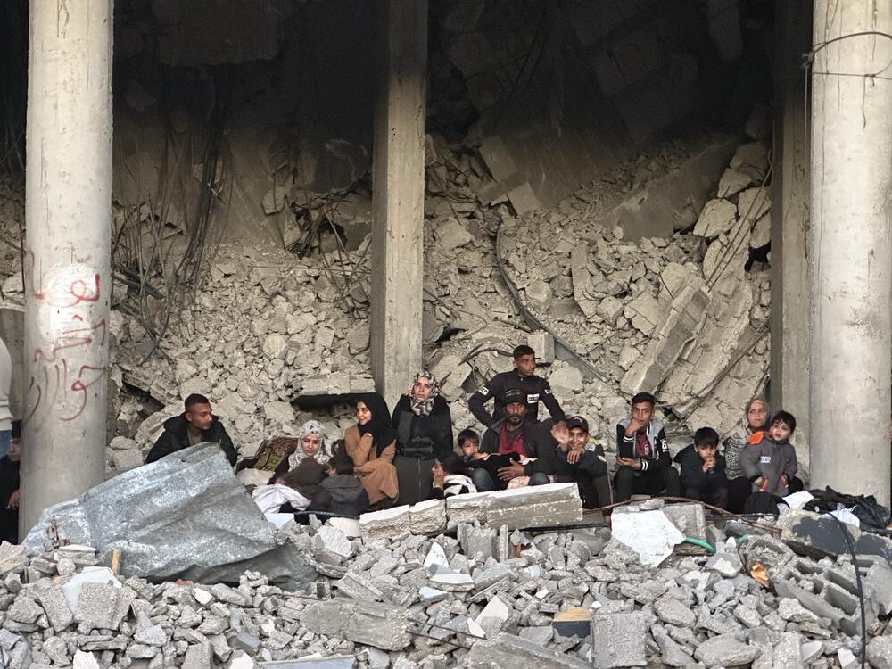 A family sits in a destroyed building in Rafah on Jan. 25, 2025.
