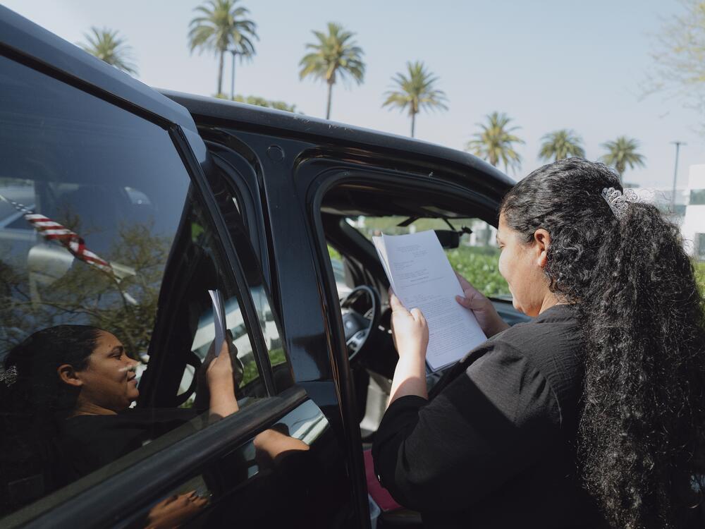After immigration court, Yasmelin Valazquez secures her paperwork inside her folder where she keeps track of her documents. April 10, 2025. Zaydee Sanchez/NPR