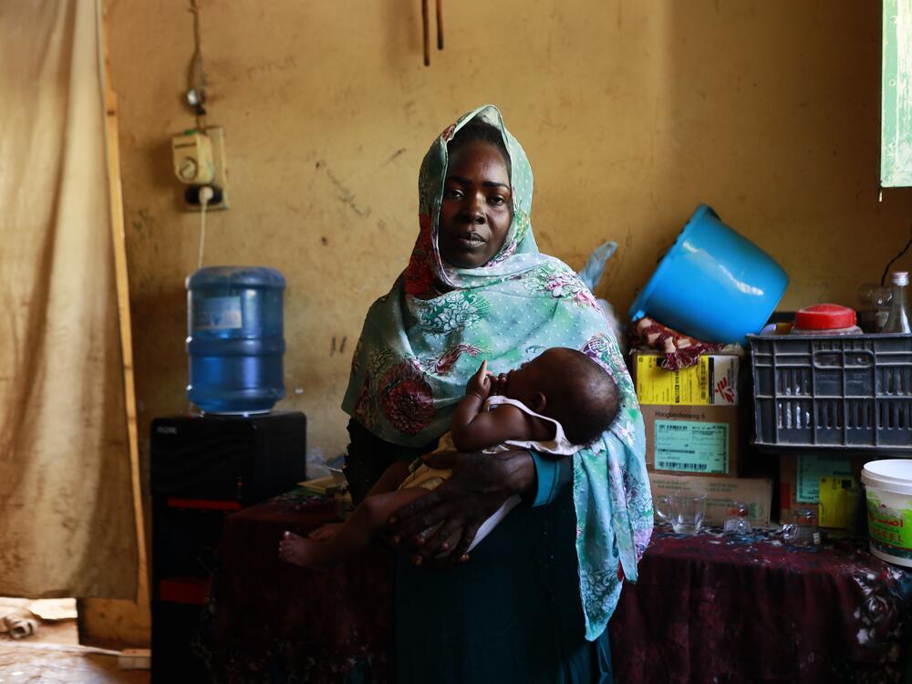 Maryam holds the 7-month-old child she gave birth to inside a refugee camp in Gezira, Sudan, on Dec. 10, 2023. She says 