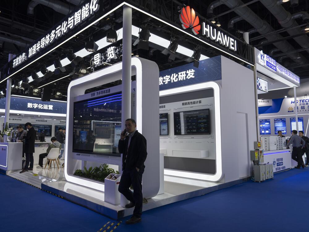 A man chats on his phone at the booth for Huawei at the 21st China International Semiconductor Expo in Beijing, in November 2024.