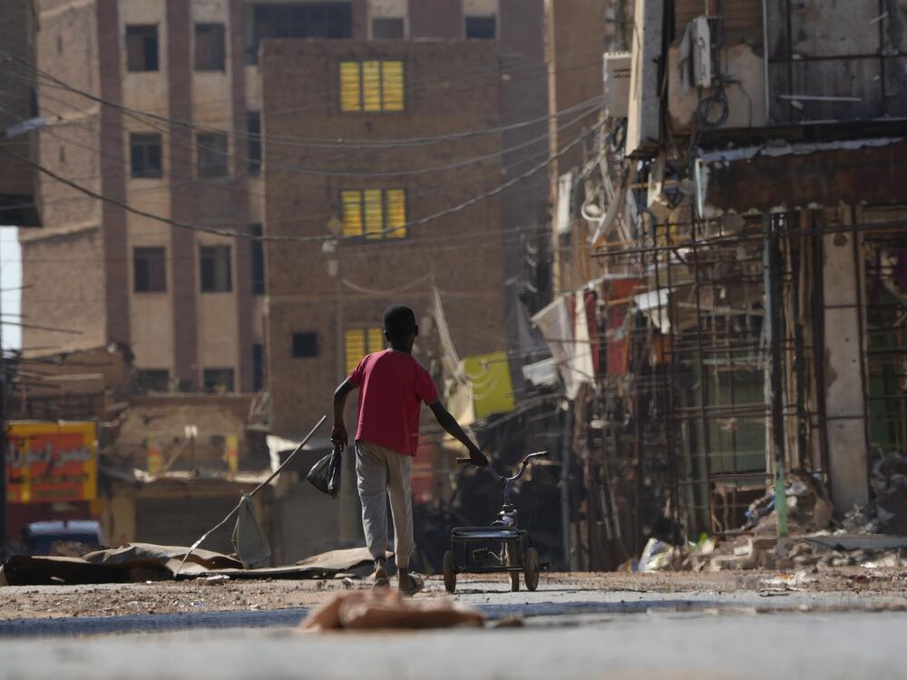 A child pushes a bicycle as he returns home in  Omdurman Market in 2024.