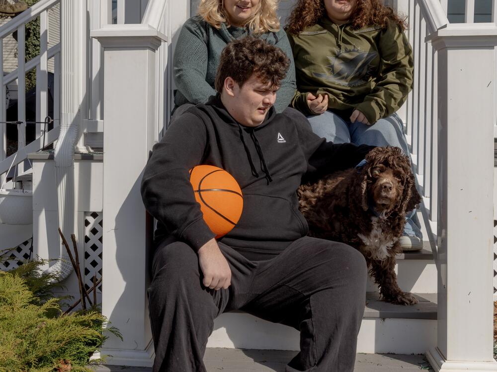 Jessie Damroth poses for a family photo with her daughter Ayden, her son Logan and Logan's dog, Miller. The family adopted Miller to help Logan, and Damroth often calls the cocker spaniel her 