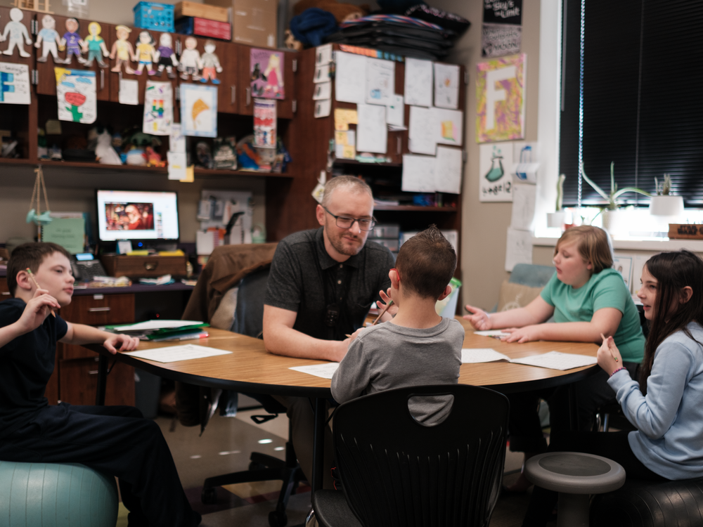 Kellen's homeroom teacher, Adam Frederick, works with Kellen and other students on a math lesson.