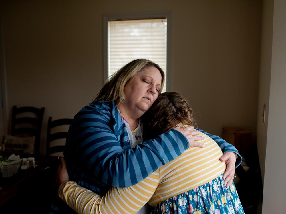 Amy Cupp hugs her daughter, G, for a portrait in her home in northern Indiana. G is 12 and has multiple disabilities. Cupp has filed a federal complaint over G's treatment in school but says the process stalled after President Trump's cuts to the U.S. Education Department.