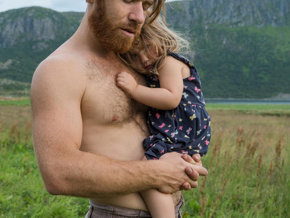 Parsa holds his daughter Arda (wearing her butterfly dress) at Polarhagen Farm in Norway.