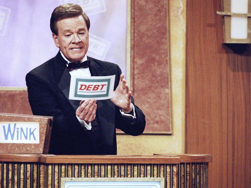 Host Wink Martindale looks at a card during game show in 1997.