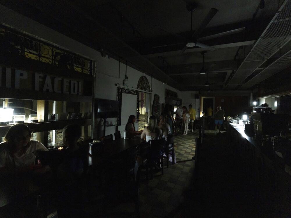 Customers sit inside a restaurant lit by battery-powered lanterns during an island-wide power outage, in Old San Juan, Puerto Rico, Wednesday, April 16, 2025.