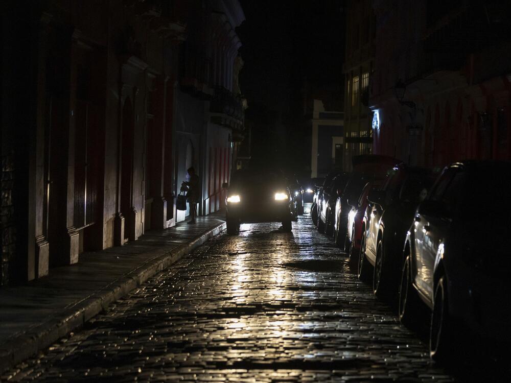 Headlights illuminate cobblestone streets in Old San Juan, Puerto Rico, during an island-wide blackout, Wednesday, April 16, 2025.