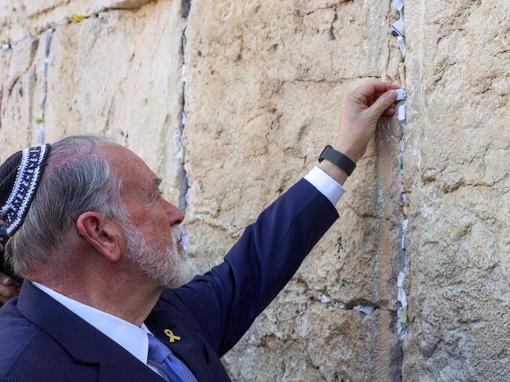 Mike Huckabee, recently confirmed as U.S. ambassador to Israel, places a note given to him from President Trump in the cracks of the Western Wall, during Huckabee's visit to the holy site in the old city of Jerusalem on April 18.