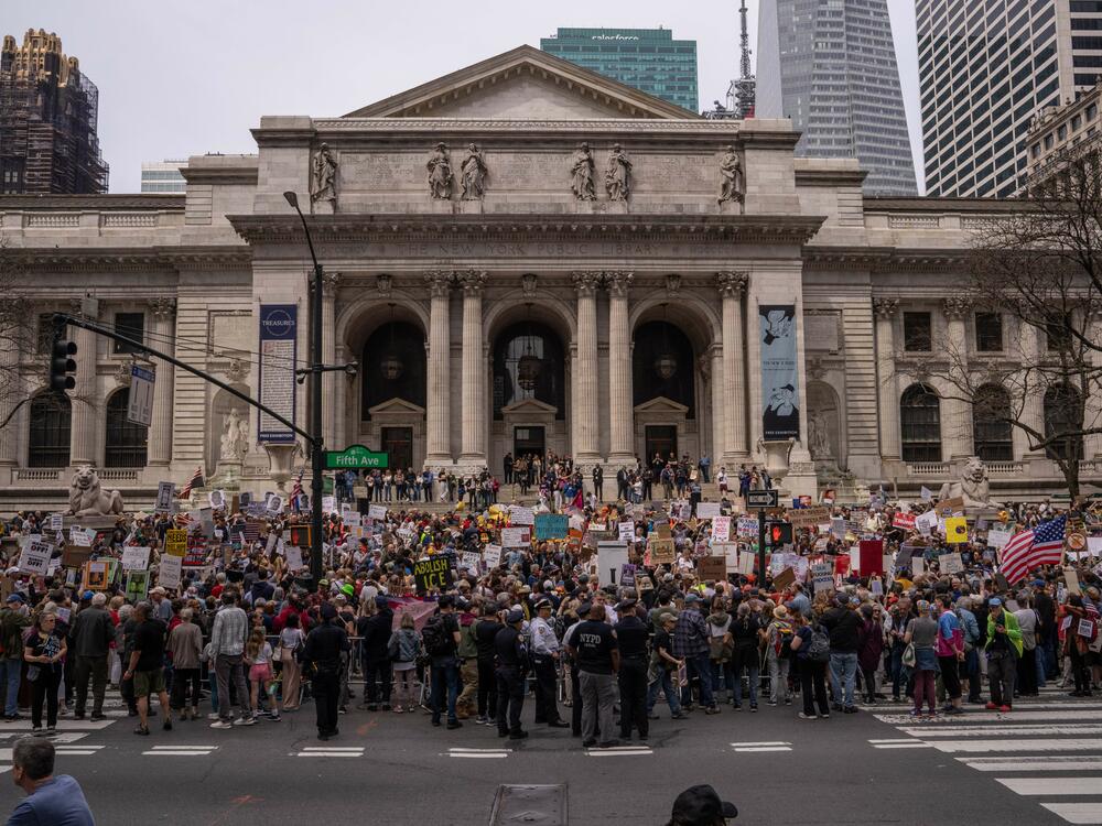 People take part in a protest outside of New York Public Library.