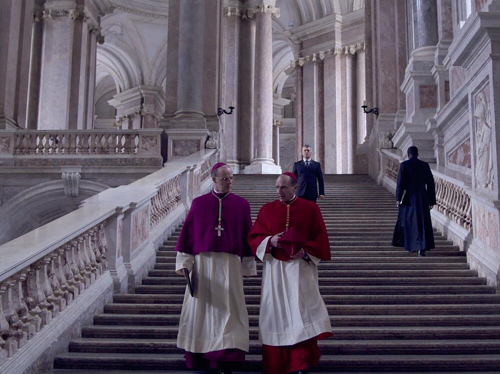 Cardinal O'Malley (Brían F. O'Byrne) and Cardinal Lawrence (Ralph Fiennes) confer in <em>Conclave. </em>