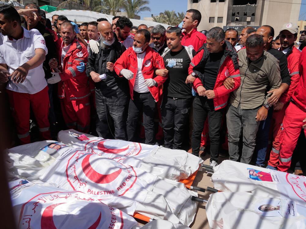 Mourners gather around the bodies of 8 Red Crescent emergency responders, recovered in Rafah a week after an Israeli attack, as they are transported for burial from a hospital in Deir al-Balah, Gaza Strip, on Monday, March 31, 2025.