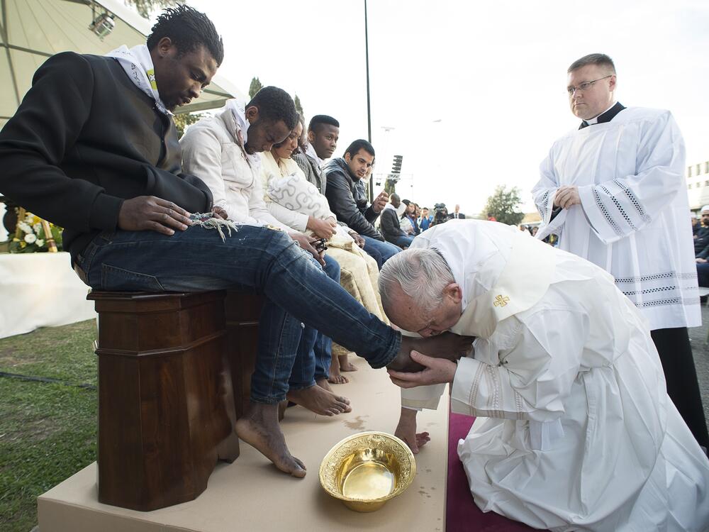 Pope Francis kisses the foot of a man during the foot-washing ritual at the Castelnuovo di Porto refugees center, some 30km (18, 6 miles) from Rome on March 24, 2016.