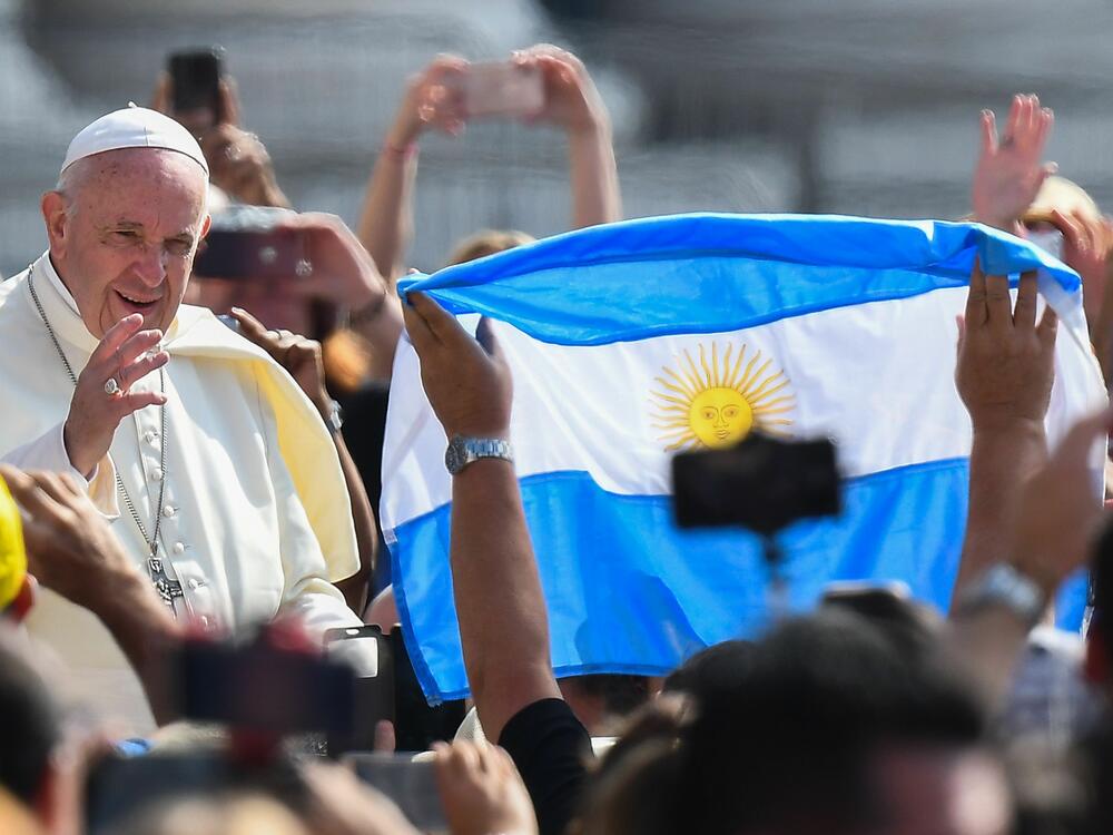 A worshiper waves the flag of Argentina as Pope Francis arrives at St. Peter's square in the Vatican in 2019.