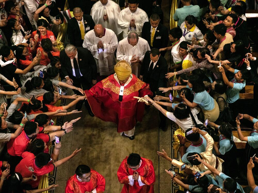 Pope Francis walks out from Assumption Cathedral as Thai youth reach out to touch him in Bangkok, Thailand, on Nov. 22, 2019.
