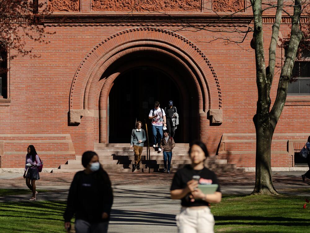 People cross Harvard Yard on Harvard University's campus in Cambridge, Mass., on Thursday.