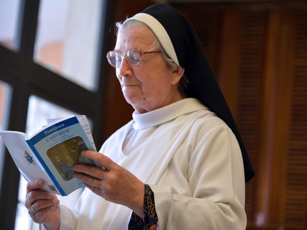 A nun reads Pope Francis's encyclical, a collection of principles to guide Catholic teaching, entitled 