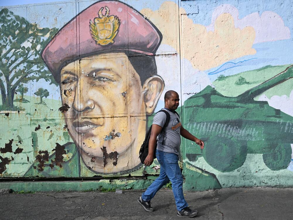 A man walks next to a graffiti with the image of the late Venezuelan President Hugo Chávez in Caracas. Political scientists say that President Trump does not enjoy the huge popular support that leaders like Chávez harnessed to dominate their nation's political systems.