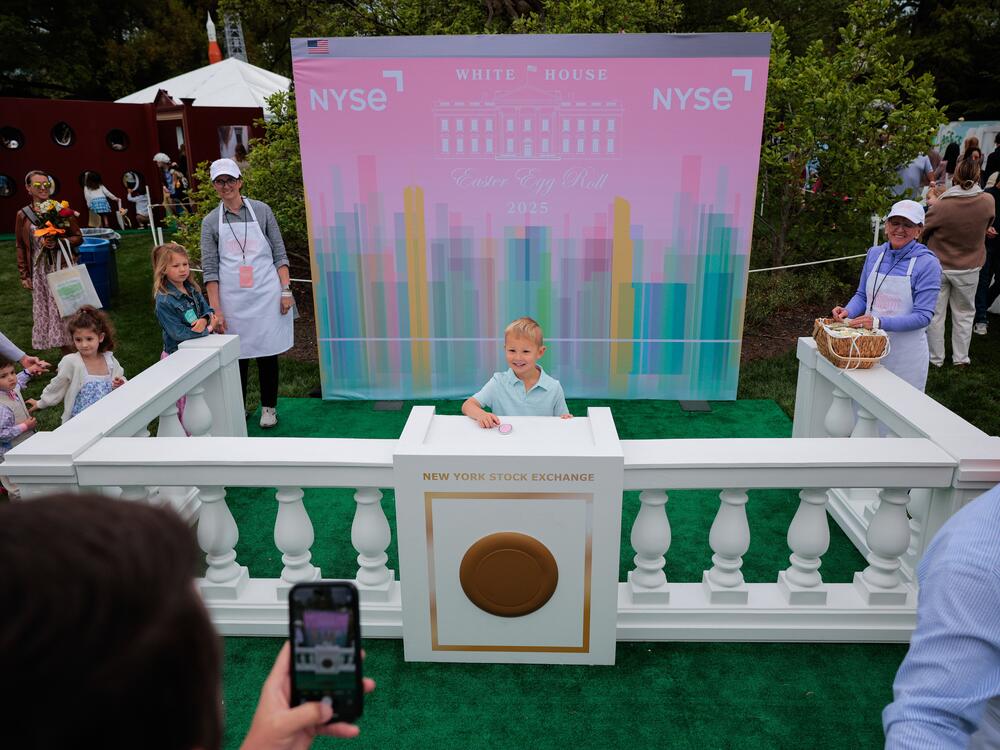 Children pose for photographs while pretending to ring the bell for the New York Stock Exchange, one of sponsors of the White House Egg Roll.