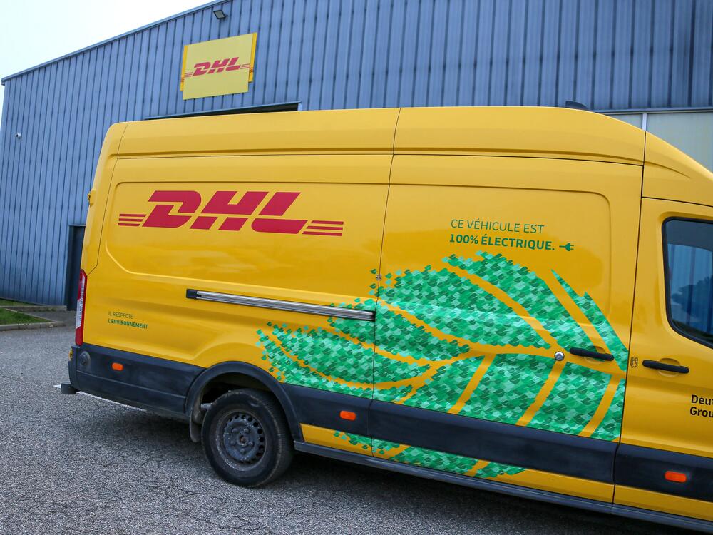 A DHL delivery vehicle is seen in front of a warehouse in Valence, France, in December 2024. The global shipping company announced it would temporarily stop shipping packages valued over $800 to U.S. consumers.