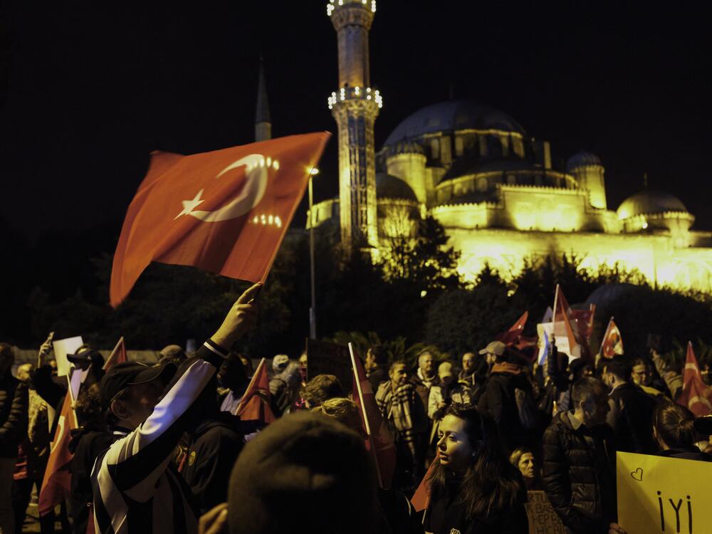 Protesters wave Turkish flags in front of the New Mosque in Istanbul. Despite a government protest ban, mass demonstrations erupted nationwide following the arrest of Istanbul Mayor Ekrem Imamoglu on corruption charges, with crowds demanding democracy and chanting 