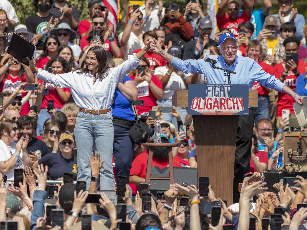 U.S. Sen. Bernie Sanders (I-Vt) And Rep. Alexandria Ocasio-Cortez (D-Ny) Hold Hands During A Stop On Their 'Fighting Oligarchy' Tour At Grand Park On April 12, 2025 In Los Angeles, California. An Estimated 36,000 People Attended The Rally Which Also Saw Neil Young And Joan Baez Perform.