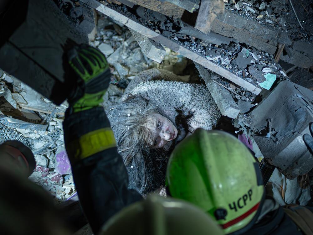 Rescue workers carry an injured victim on a stretcher in front of a house that was destroyed by a Russian strike in a residential neighborhood in Kyiv, Ukraine, on Thursday.