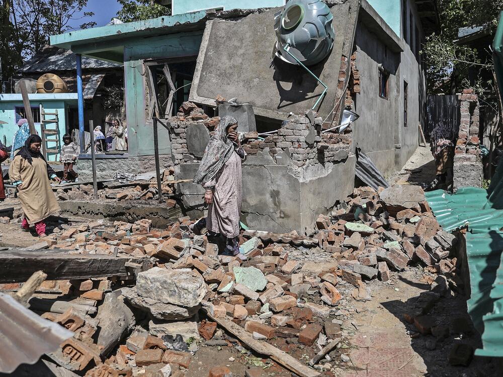Soldiers in Indian-administered Kashmir blew up the family homes of two men suspected of carrying out Tuesday's deadly attack on tourists in Pahalgam. People walk through the debris of a demolished house related to the family of one of the suspects in southern Kashmir on Friday.