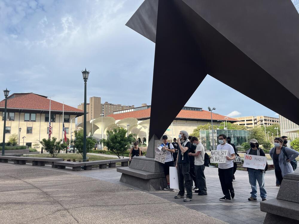 A small group of student protesters from the adjoining University of Texas at Austin gathers outside Natal Con.