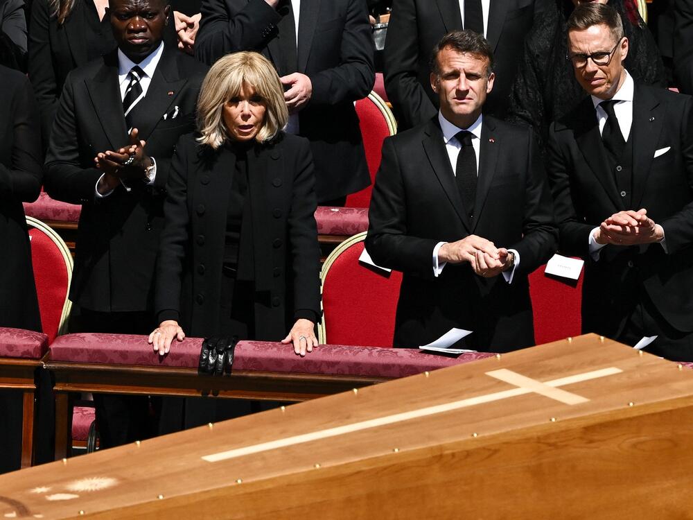 France's President Emmanuel Macron and his wife Brigitte Macron watch as the coffin of Pope Francis is carried by pallbearers during his funeral.