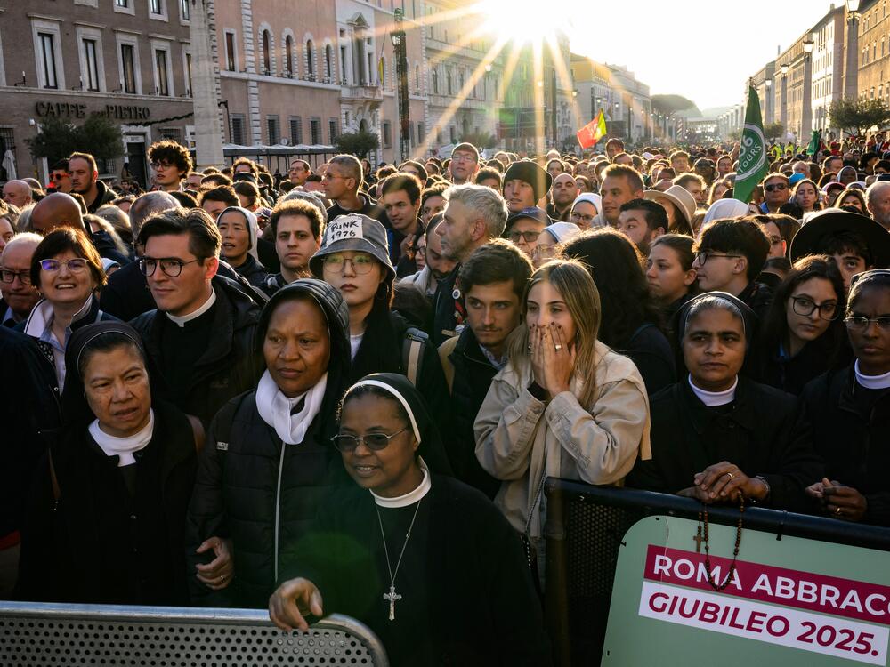 Attendees and nuns stand in the street as they wait before late Pope Francis' funeral ceremony.