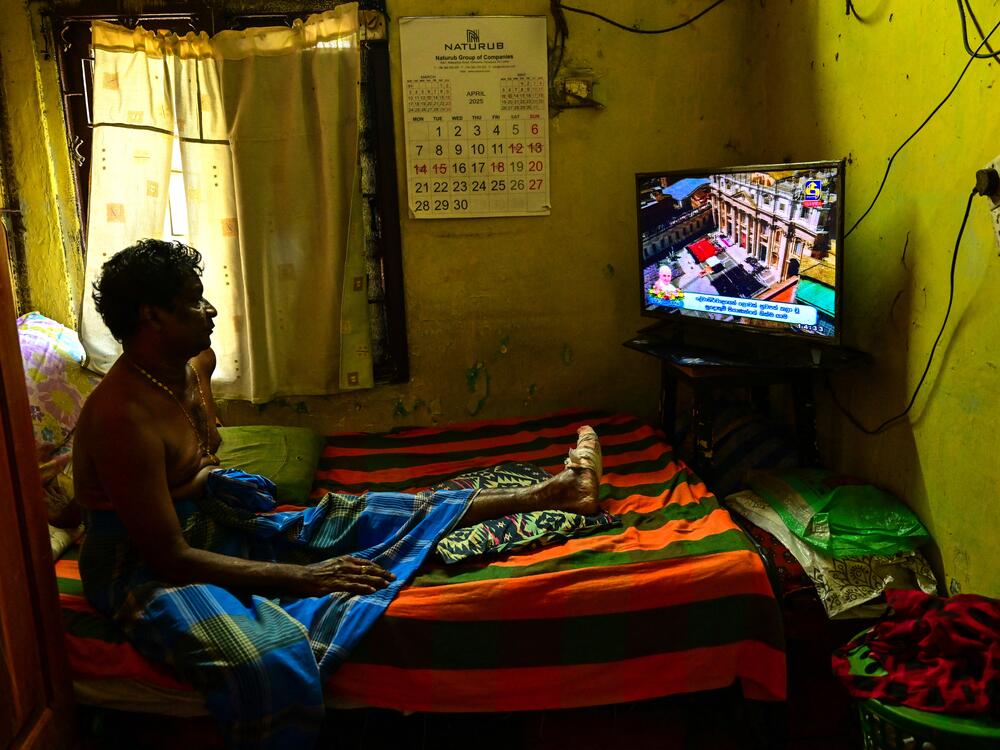 A Catholic man watches a live telecast of the funeral for the late Pope Francis taking place at St Peter's Square in the Vatican, in Colombo.