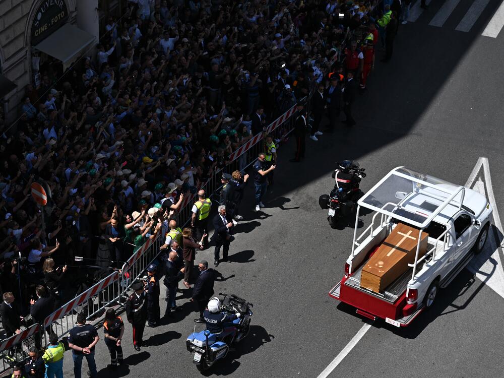 People gather along the road as the coffin of late Pope Francis is transported from St Peter's Basilica to Santa Maria Maggiore Basilica during the funeral ceremony.