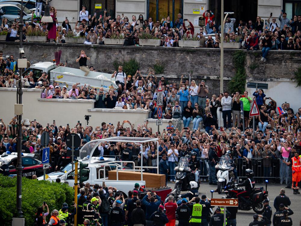 People gather along the road as the coffin of the late Pope Francis is transported from St. Peter's Basilica to Santa Maria Maggiore Basilica during the funeral ceremony.