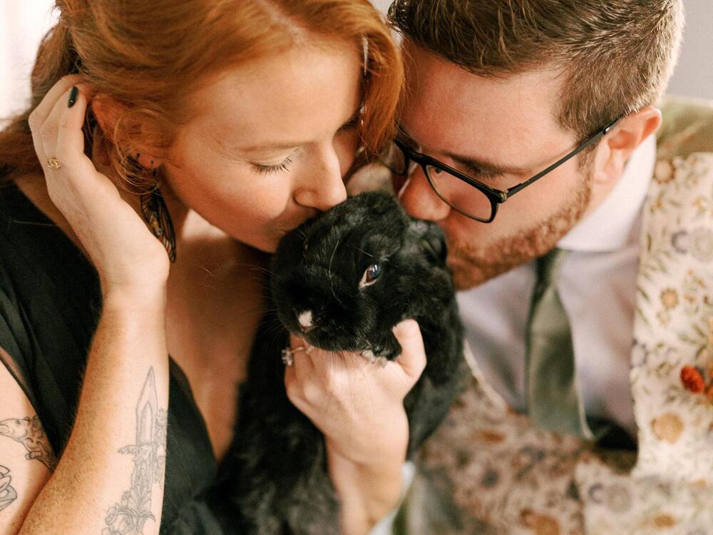 Olivia Poelmann and her husband kiss their rabbit Sirius.
