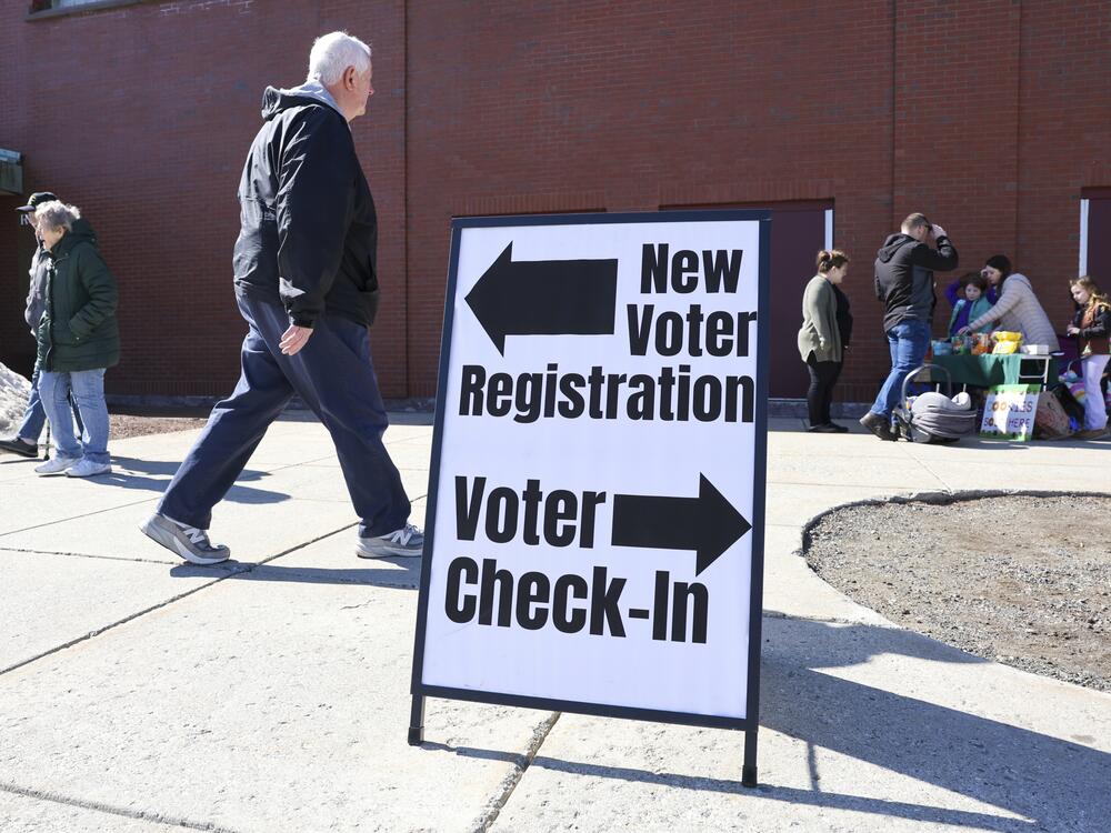 A sign for new voter registration is seen outside a polling location in Derry, N.H., on March 11.