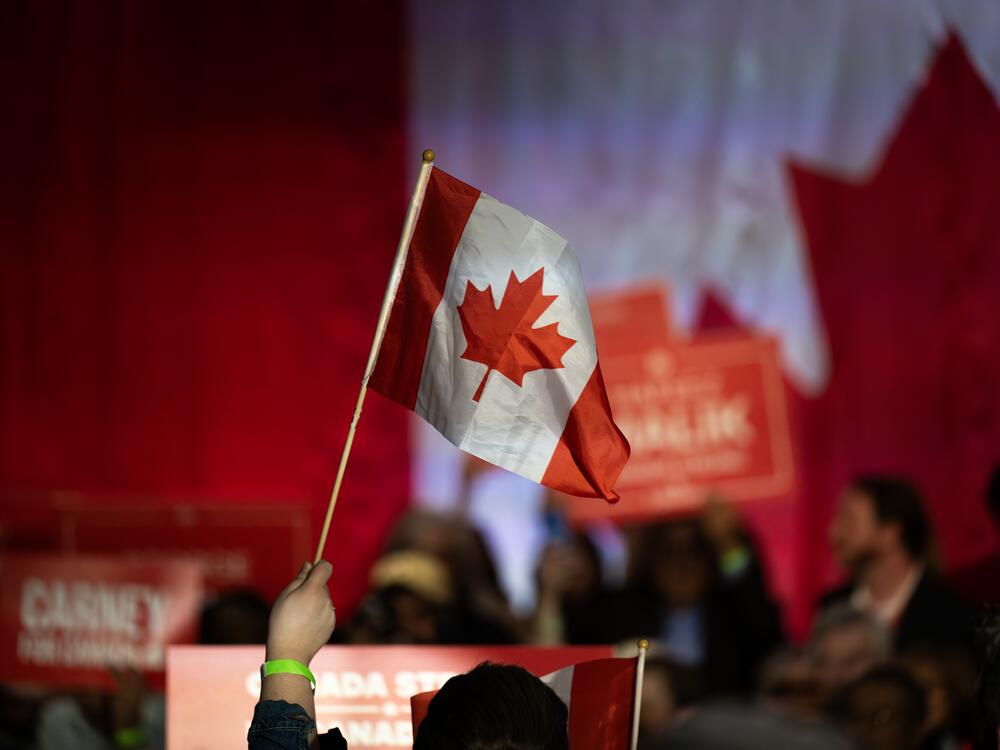 A supporter waves a Canadian flag during a campaign rally for Mark Carney, Canada's prime minister, in Calgary, Alberta, Canada, on Tuesday, April 8, 2025. Carney said Donald Trump's tariff policy is an act of economic self-sabotage that's pushing the US into a downturn. Photographer: Gavin John/Bloomberg via Getty Images