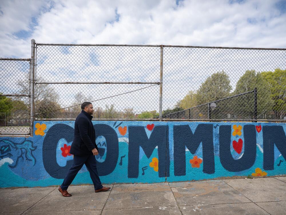Baltimore City Councilman James Torrence, who represents Sandtown-Winchester, walks by a neighborhood mural.